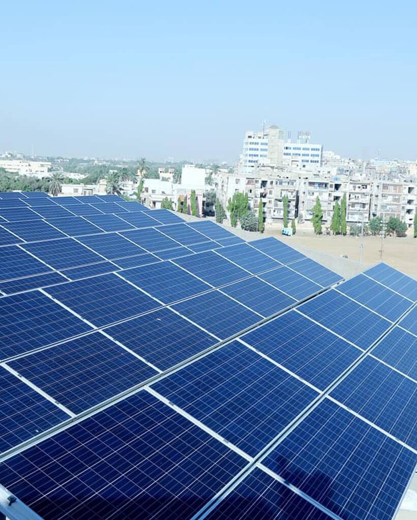 Solar panels on a Karachi rooftop with UB Solar Solution team